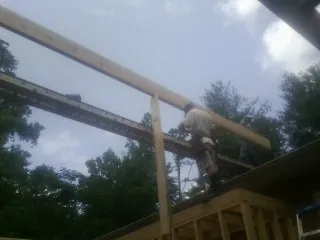 Carpenter setting a ridge beam over a new addition frame — Ice Dam Removal by Roofing Brothers in Indian Orchard
