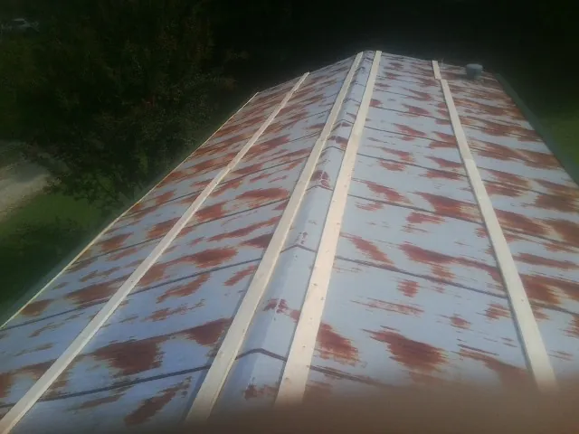 Rusted metal roof panels with new wood purlins before replacement — Storm Damage Roof Repair in Indian Orchard by Roofing Brothers