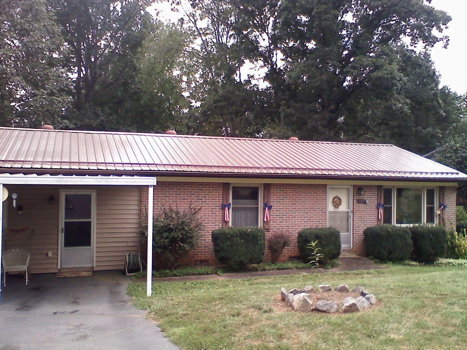 Bronze metal roof and carport on a brick ranch home — Roof Repair work by our crew in Indian Orchard